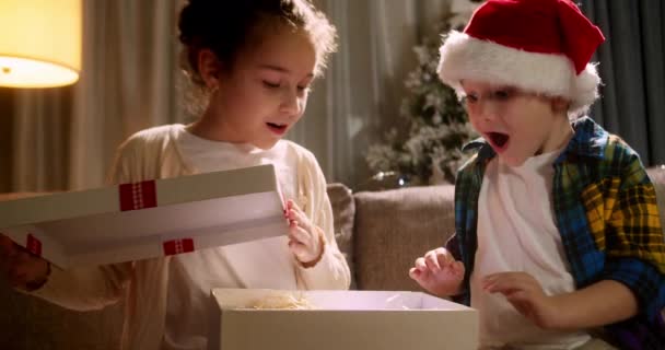 선물을 좋아하는 행복하고 귀여운 아이들은 크리스마스 선물을 선물로부터 기쁨을 느끼며 — 비디오