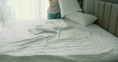 Kadınlar odadaki yatağı değiştiriyor. Çalışanlar, iki otel hizmetçisi, profesyonel olarak müşteri odasındaki yatağı yapıyor. Beş yıldızlı otel konsepti ve kaliteli oda servisi. 4K Yavaş çekim.