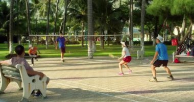 Nha Trang, Vietnam - 10 01 2022: Nha Trang halk parkında sabah egzersizi, insanlar badminton oynuyor. Mutlu emekliler spor yapmak için babinton 'a gidiyor.