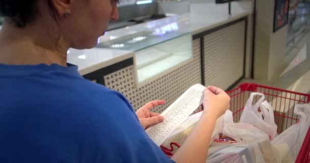 Женщина Проверяет Бумажный Чек После Покупки Продуктов Торговом Центре Проверяя — стоковое видео