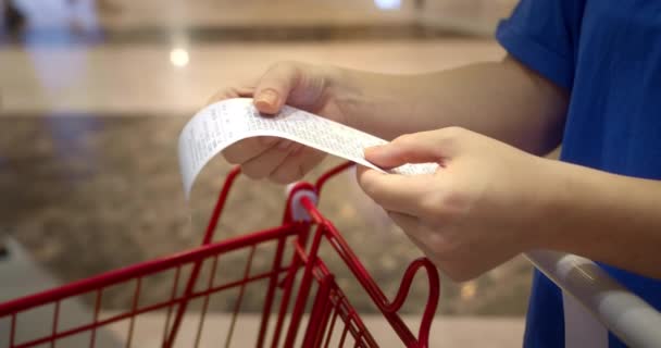 Frau Überprüft Papierscheck Nach Dem Einkauf Für Lebensmittel Einkaufszentrum Indem — Stockvideo