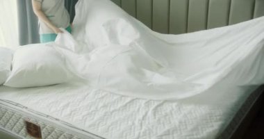 Kadınlar odadaki yatağı değiştiriyor. Çalışanlar, iki otel hizmetçisi, profesyonel olarak müşteri odasındaki yatağı yapıyor. Beş yıldızlı otel konsepti ve kaliteli oda servisi. 4K Yavaş çekim.