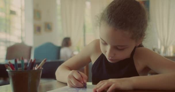 幸せな子供の女の子10歳は自宅でリラックスし 自宅に座って色鉛筆で紙の上に描画します 白人の子供が家で絵を描く — ストック動画
