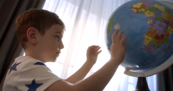 朝の光の中で子供 地球と虫眼鏡を持つ子供 少年のための技術 子供は地球を見て 世界を探索します 学びます — ストック動画