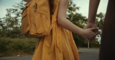 Mutlu aile annesi ve kızı, yol boyunca parktan geçerek el ele okula gidiyorlar. Arkalarında sırt çantası olan bir kız ve kız öğrenci. Mutlu kız okula dolu bir sırt çantasıyla gidiyor..