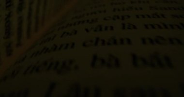 Kitap sayfaları arasında hareket eden bir kamera. Makro görüntüyü kitabın içinden hızla geçiriyor. Vietnam metniyle kapatılan kitap sayfaları. Detaylı Vietnam metnini içeren Macro görünüm beyaz sayfaları