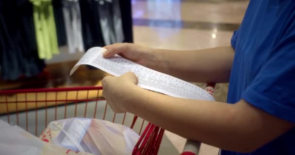 Жінка Перевіряє Паперовий Чек Після Покупок Продуктами Торговому Центрі Перевіряючи — стокове відео