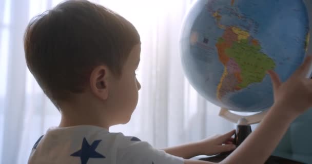 孩子们在清晨的阳光下 带着地球仪和放大镜的孩子们 男孩子们的科技 孩子们看着地球 探索世界 — 图库视频影像
