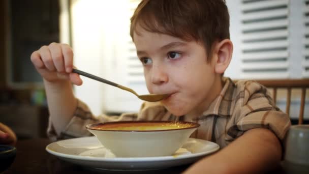 Zamknij Ładny Chłopczyk Siedzi Przy Stole Kuchni Domowej Jedząc Suche — Wideo stockowe