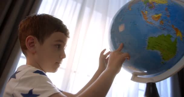 朝の光の中で子供 地球と虫眼鏡を持つ子供 少年のための技術 子供は地球を見て 世界を探索します 学びます — ストック動画