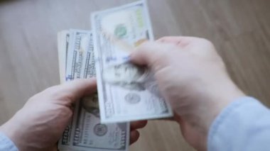 Amerikan Doları 'nın faturalarını sayan ya da nakit ödeme yapan eller. Yatırım, başarı, finansal beklentiler veya kariyer ilerlemesi kavramı.