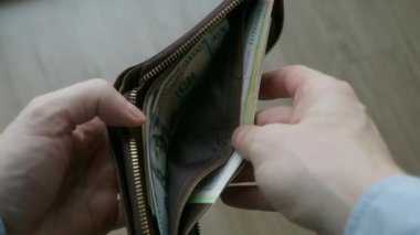 Erkek eli, içinde dolar ve avro olan bir cüzdanı açıyor. Finansal kriz, yoksulluk kavramı, ısınma için ödeme, ekonomik kriz ve iş yerindeki sorunlar, tasarruf eksikliği, küresel işsizlik
