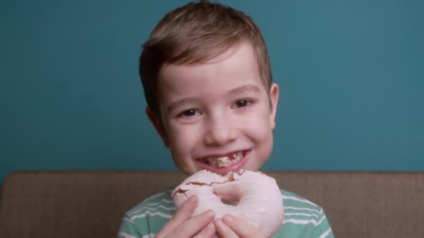 10岁的孩子在釉面上吃着甜甜的甜食甜甜圈 快乐的高加索小女孩吃着甜甜甜圈 一个吃甜糕点的孩子的嘴的特写 — 图库视频影像