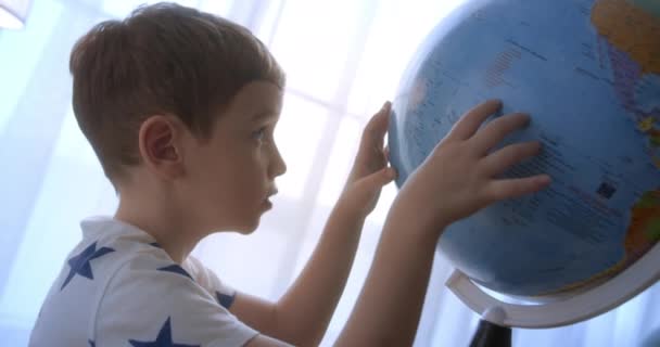 孩子们在清晨的阳光下 带着地球仪和放大镜的孩子们 男孩子们的科技 孩子们看着地球 探索世界 — 图库视频影像