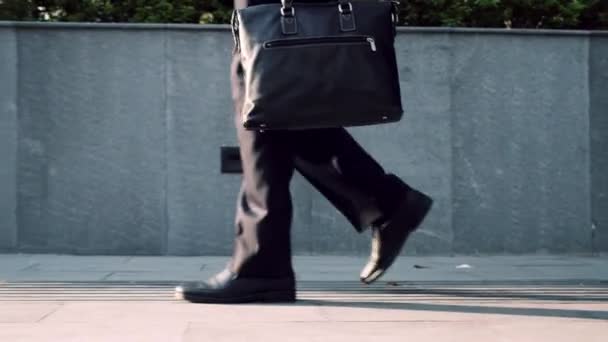仕事に通勤するビジネスマンの後ろ足 革の靴に自信のある男とスーツオフィスビルに行く途中にある — ストック動画