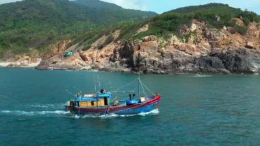 Vietnam 'daki balıkçılar Nha Trang, güneşli bir günde güzel bir manzaranın ve harika dağların zemininde yelken açıyorlar. Güneşli bir sabahta, balıkçı teknesi deniz mahsullerini yakalamak için acele eder.