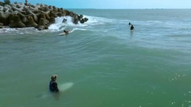 Sörfçü gün batımında Vietnam 'da büyük dalgalara biner. Sakallı yakışıklı, deniz dalgalarında sörf yapmaktan mutlu, sörf yapmaktan memnun. Emekli sporcu denizde sörf yapıyor, okyanus hayatı sürüyor, ekstrem sporlar yapıyor.