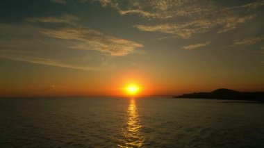 İnsansız hava aracından ateş etmek, deniz boyunca uçmak günbatımının arka planına ve bir balıkçı teknesine karşı. Denizde balıkçılar gün batımında balık tutuyorlar. Güzel, sakin bir gün batımı Denizde tek bir yat.