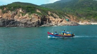 Vietnam 'daki balıkçılar Nha Trang, güneşli bir günde güzel bir manzaranın ve harika dağların zemininde yelken açıyorlar. Güneşli bir sabahta, balıkçı teknesi deniz mahsullerini yakalamak için acele eder.