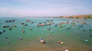 Mui Ne, Vietnam 'da balıkçı köyü. Mui Ne Balıkçı Köyü, fırtınalardan korunmak için birkaç yüz balıkçı teknesiyle uçarken, Vietnam 'ın ortasında güzel bir körfezdir. Asya balıkçı tekneleri. 4K.