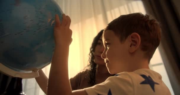 朝の光の中で子供 地球と虫眼鏡を持つかわいい男の子 少年のための技術 子供は地球を見て 世界を探索し 学びます — ストック動画