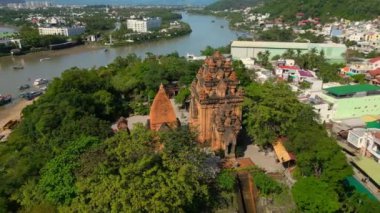 Kule, uzun pagoda ve mavi gökyüzünün arka planına karşı. Vietnam 'ın La Lao Dağı' ndaki Ponagar Kulesi 'nin havadan görünüşü Nha Trang' ın Vietnam simgelerinden biridir. Turistler Ponagar 'da fotoğraf çekiyor