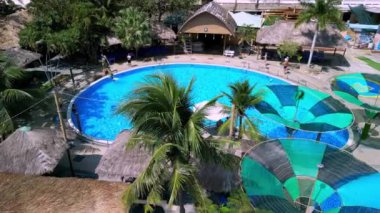 Vietnam, Nha Trang 'da bir tatil köyünde havuz manzarası. Sahildeki tatil beldeleri konseptinden romantik plaj videoları.