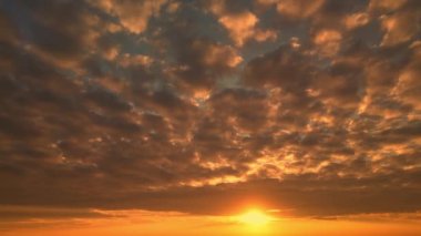 Gün batımında kuş bakışı bir bakış açısıyla doğal bulutların yavaş hareket etmesi. Tropikal cennet Vietnam, Endonezya, Asya 'da günbatımı dalgalı deniz manzarası. Bir dron tarafından çekilen yumuşak güneş ışığında doğanın sinematik bir manzarası. 4K