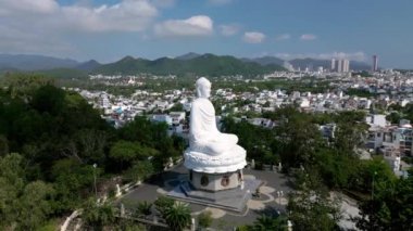 Hava görüntüsü 4k. Güneşli bir günde, Vietnamlı Büyük Buda 'nın üzerinde. Büyük Buda' nın sisli beyaz heykeli. Beyaz Buda Vietnam, Nha Trang Vietnam 'ın simgelerinden biridir. 4K.