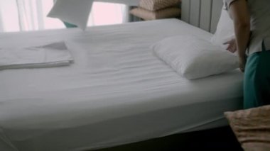 Kadınlar odadaki yatağı değiştiriyor. Çalışanlar, otelin iki hizmetçisi, müşteri odasındaki yatağı profesyonel olarak hazırlıyorlar. Beş yıldızlı otel konsepti ve kaliteli oda servisi. 4K.