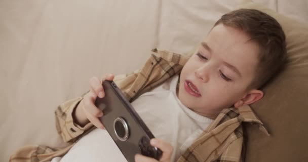 집에서 스마트폰으로 모바일 게임을 아름다운 소년입니다 전화를 귀여운 게임용 전화기를 — 비디오