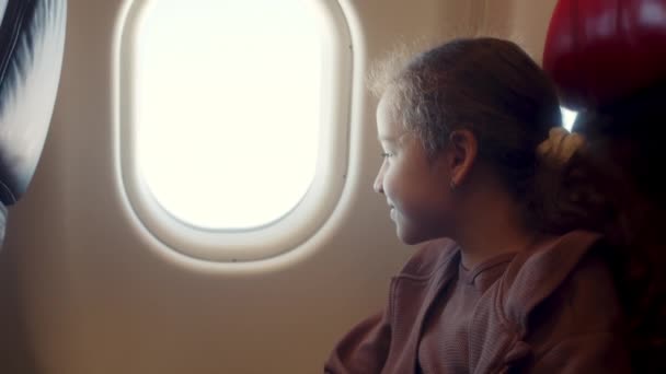 Een Charmant Meisje Zit Aan Het Raam Van Het Vliegtuig — Stockvideo