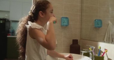 Portre, banyoda dişlerini fırçalayan ve gülümseyen mutlu bir çocuk. Bebek günlük sağlık hizmeti rutini. Kafkasyalı çocuk evde aynaya bakıyor. Yaşam biçimi.