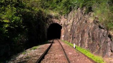 Trenin tünelden geçişi. Tren tüneli girişi çekiliyor. Şehirler ve ülkeler arasındaki konteynırlarda kargo taşıma ve teslimatı. Tren yolculuğu için tünel üzerinden görüntüler.