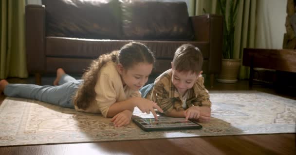 Счастливые Двое Детей Брат Сестра Лежащие Дома Теплом Полу Играют — стоковое видео