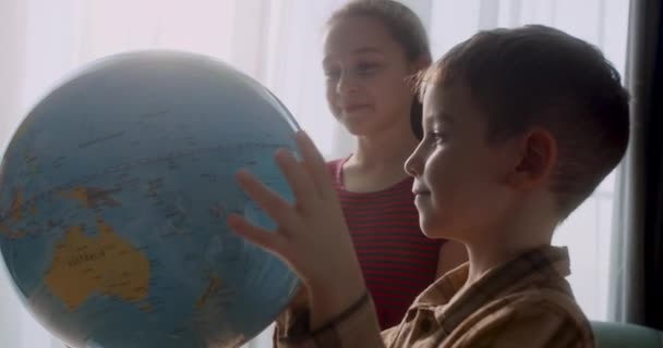朝の光の中で子供 かわいい少年グローブと虫眼鏡付きの子供 小学生のための技術 子供は地球を見て — ストック動画