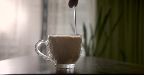 コーヒーとマグカップ人の手はスプーンでコーヒーを攪拌し コーヒー泡を攪拌します フィルターホルダーを使用する 朝焙煎黒コーヒーを飲む — ストック動画