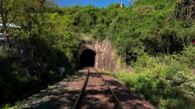 Trenin tünelden geçişi. Tren tüneli girişi çekiliyor. Şehirler ve ülkeler arasındaki konteynırlarda kargo taşıma ve teslimatı. Tren yolculuğu için tünel üzerinden görüntüler.