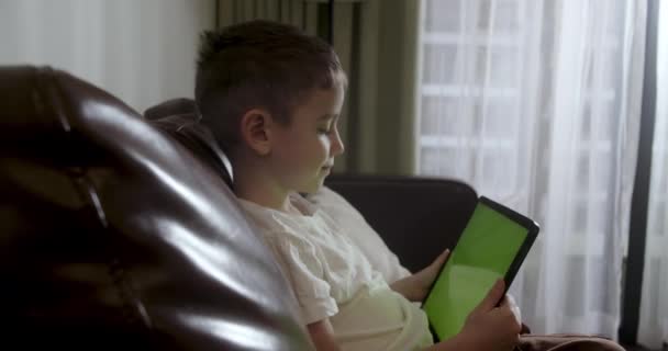 Ciekawy Uroczy Chłopiec Przedszkola Korzystający Cyfrowych Tabletów Siedzący Sam Kanapie — Wideo stockowe