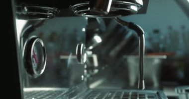 Barista kahve makinesine öğütülmüş kahve koyar. Makineden fincana akarsu kahve dökmek. Sabahları kavrulmuş sade kahve hazırlama kavramı. Ev yapımı sıcak espresso..