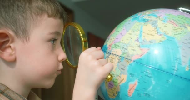 Criança Bonito Anos Idade Olha Para Globo Através Lupa Tecnologia — Vídeo de Stock