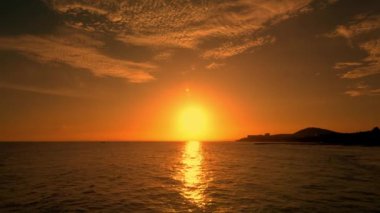 Vietnam 'da deniz üzerinde parlak kırmızı gün batımı. Gün batımında deniz dalgalarında sörf yapmak. 4K.