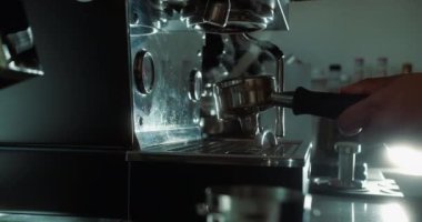 Barista kahve makinesine öğütülmüş kahve koyar. Makineden fincana akarsu kahve dökmek. Sabahları kavrulmuş sade kahve hazırlama kavramı. Ev yapımı sıcak espresso..