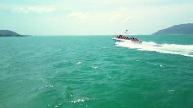 Nha Trang, Vietnam - 10 Şubat 2023: Sürat teknesi turistlerle birlikte Vietnam 'da bir deniz gezisinde. Mutlu insanlar, sürat teknesi sineğiyle deniz dalgalarına binmekten mutlular. 4K.