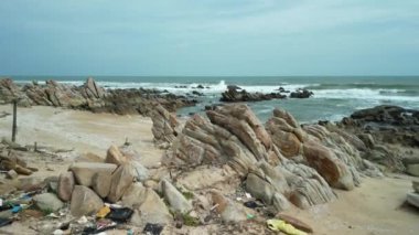Nha Trang Vietnam 'ın kumlu sahilinde plastik atık. Çöpler plajları kirletiyor ve turistleri kaçırıyor. Plastik atıklar sahil hayvanlarının yaşam alanını yok ediyor. 4K.