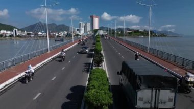 Trafiğin en yoğun olduğu saatte motosikletlerin ve arabaların hava görüntüsü karayolu caddesinde Nha Trang Downtown 'da köprü üzerinde, Asya' da kentsel şehir, gün batımında Vietnam. 4 bin. Asya trafiği.