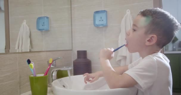 肖像画快乐可爱的幼儿在浴室刷牙和微笑 婴儿日常保健例程 白人小孩刷着镜子在家里 生活方式 — 图库视频影像