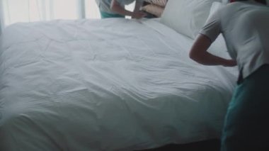 Kadınlar odadaki yatağı değiştiriyor. Çalışanlar, otelin iki hizmetçisi, müşteri odasındaki yatağı profesyonel olarak hazırlıyorlar. Beş yıldızlı otel konsepti ve kaliteli oda servisi. 4K.