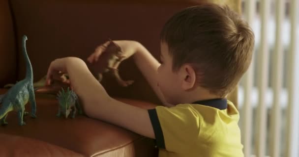 Χαριτωμένο Παιδί Προσχολικής Ηλικίας Παίζει Παιχνίδια Παίζει Δεινόσαυρους Παιχνίδια Καναπέ — Αρχείο Βίντεο