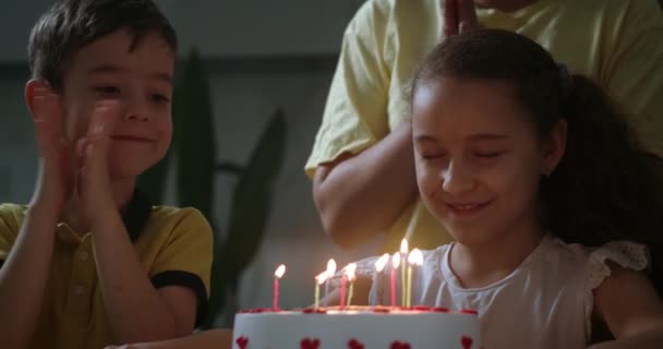가족들은 생일을 축하하고 아이는 케이크 위에서 촛불을 컨셉트 — 비디오